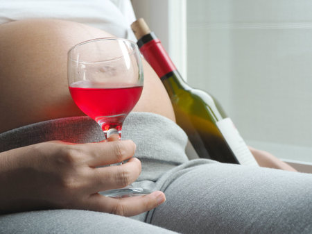 Pregnant woman with glass of wine in handの写真素材