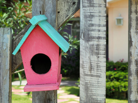 Old bird house or nest box hangs on the wooden fence.の写真素材