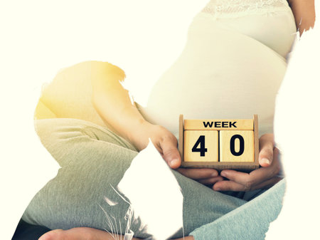 Double exposure of young man kissing the belly of his lovely pregnant wife and calendar 40 weeksの写真素材