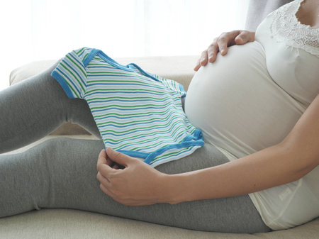 Pregnant woman preparing baby clothes