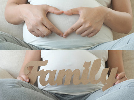 Pregnant woman holding her finger in heart and family message for incoming baby. Concept for baby shower and warm family.の写真素材