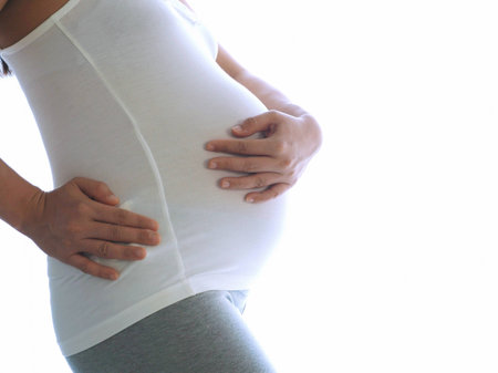 Pregnant woman with hands over tummy isolated on white background. Concept about taking care Pregnancy.の写真素材