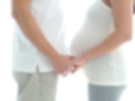 Blur background image of pregnant couple standing close together with holding the hand. Concept of warm and happy family.の写真素材