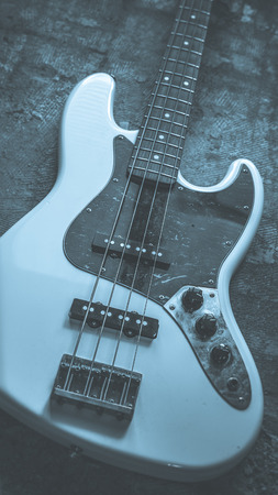 Old vintage electric bass guitar on basement floorの写真素材