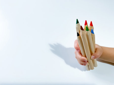 Childs hand holds colored pencils. Learning and drawing conceptの写真素材