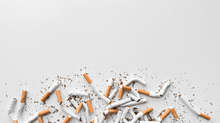 Discarded crushed broken cigarettes and scattered tobacco on white background, representing cessation and the end of smoking with copy space. No tobacco day.の写真素材