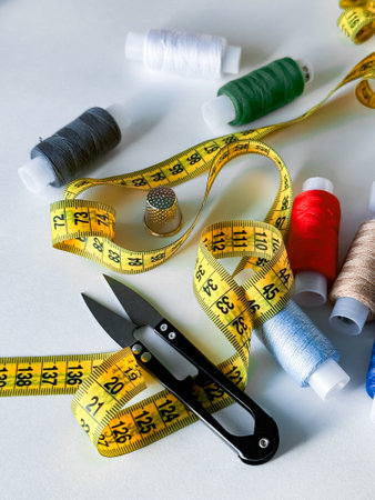 Sewing essentials. Measuring tape, threads, scissors, and thimble for tailoring projects