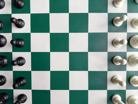 Top view of chess pieces on a green and white checkered boardの写真素材