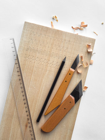 Wood carving tools on a wooden board with ruler and shavingsの写真素材