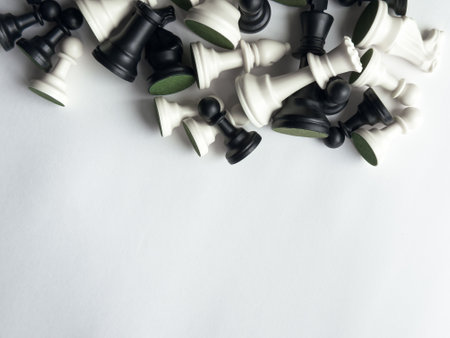 Collection of black and white chess pieces on a minimalist white backgroundの写真素材