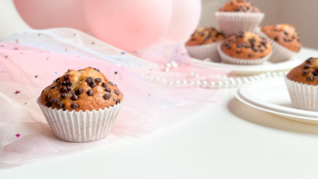 Chocolate chip muffins on elegant pink tulle with pearls and balloons. Birthday conceptの写真素材