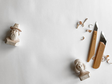 Wood carving art. Handcrafted figurines and tools on white backgroundの写真素材