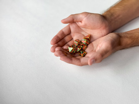 Hands presenting colorful rpg dice set on white background