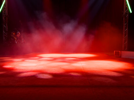 Empty stage with red lights and smoke effects in theater settingの写真素材