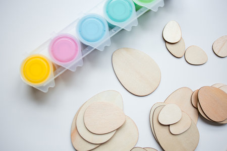 Colorful paints and wooden Easter egg shapes for crafting and creativity