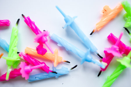 Colorful twisted birthday candles on white surfaceの写真素材