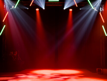 Colorful stage lighting with red and white spotlights in dark roomの写真素材