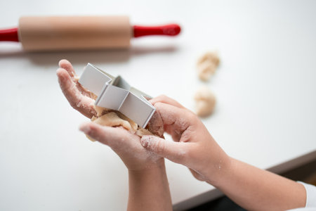 Child making cookies with dough and cutterの写真素材