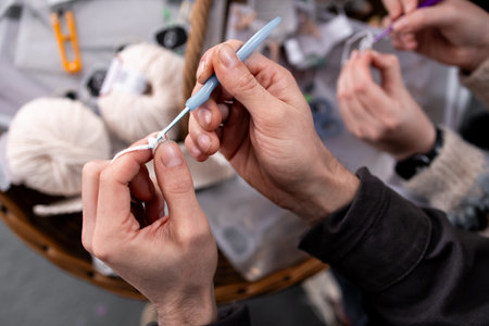 Close up of adults crocheting with yarn and hooksの写真素材