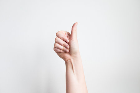 Caucasian hand giving thumbs up against white backgroundの写真素材