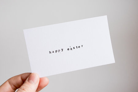 Minimalist Happy Easter card with hand-holding caucasian adultの写真素材