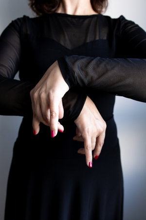 Female adult caucasian in black outfit performing expressive hand gestureの写真素材