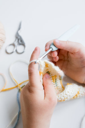 Close up of hands crocheting a colorful pattern with crochet hook and yarnの写真素材