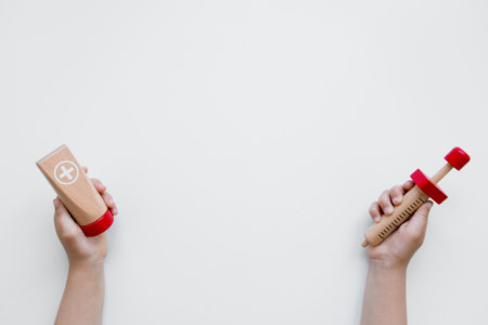 Child hands holding wooden doctor toys on white backgroundの写真素材