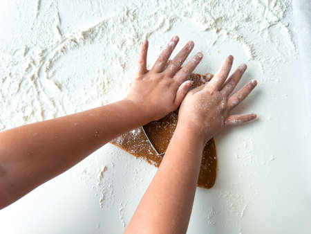 Childs hands kneading dough on flour covered surfaceの写真素材