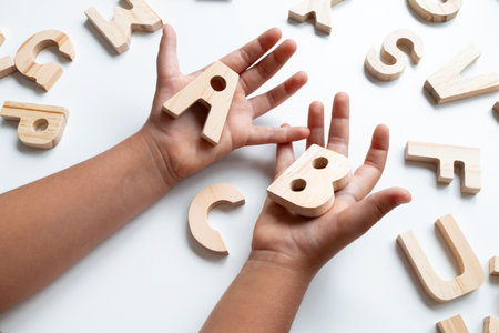 Children wooden alphabet letters held by child hands
