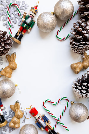 Festive Christmas arrangement with nutcrackers, ornaments, candy canes, and pinecones on white backgroundの写真素材