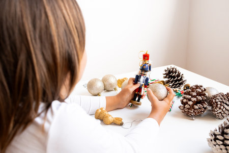 Young caucasian female child holding nutcracker with Christmas decorations