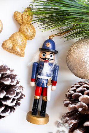 Festive nutcracker ornament with glittering decorations and pinecones in holiday setting