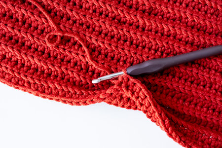 Close up of red crochet fabric with hook for knitting enthusiastsの写真素材