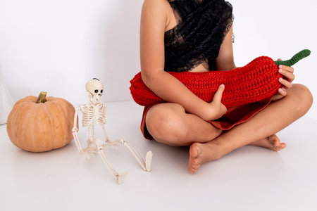Child Halloween scene with skeleton and crochet chili pepperの写真素材