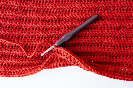Red crochet with hook on white surfaceの写真素材