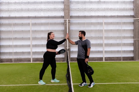 Young caucasian adults playing paddle tennis on indoor court