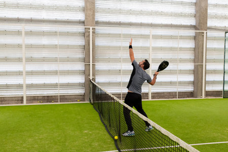 Young caucasian male playing paddle tennis indoorsの写真素材