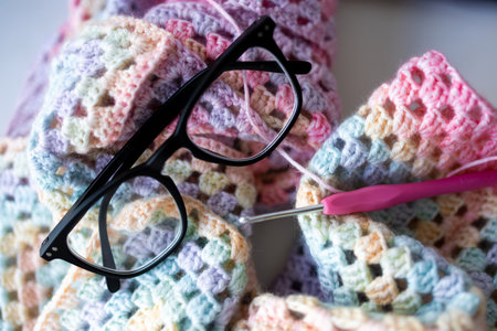 Colorful crochet project with glasses and hook in pastel yarn
