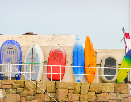 Fisher boat and surfboards lined up against a wall to dryの写真素材