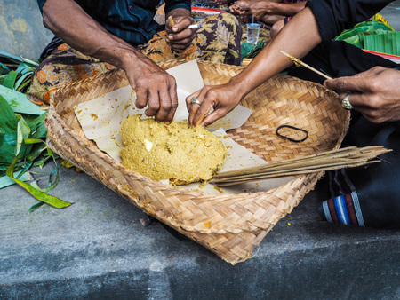 Two men making traditional Balinese satay in a local temple in Ubid for Nyepi Festivalの写真素材