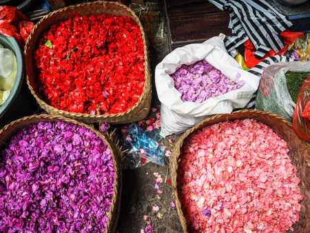 Baskets full with colorful flower pertals used for daily offerings sold at the Ubud market, Bali, Indonesiaの写真素材