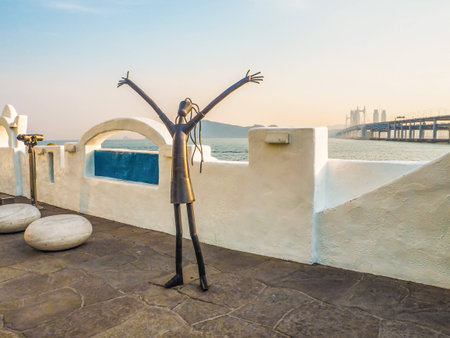 Metal sculpture on the Haeundae promenade promoting the Busan International Film Festival with the Gwangan bridge in the background during sunset, Busan, South Koreaのeditorial素材