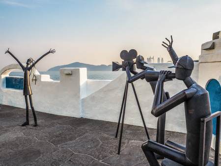 Metal sculptures on the Haeundae promenade promoting the Busan International Film Festival with the Gwangan bridge in the background during sunset, Busan, South Koreaのeditorial素材