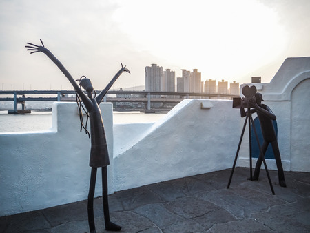 Metal sculptures on the Haeundae promenade promoting the Busan International Film Festival with the Gwangan bridge in the background during sunset, Busan, South Koreaのeditorial素材