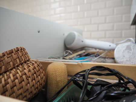 Messy open bathroom drawer with cosmetics and hairdryerの写真素材