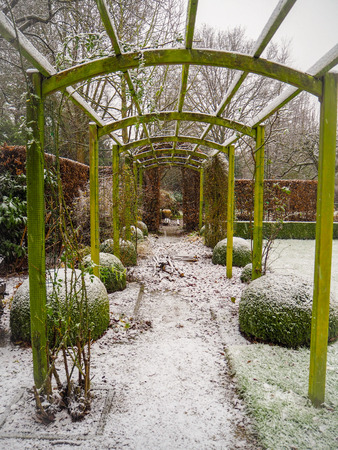 Wooden pergola structure during winter a in snow covered gardenのeditorial素材