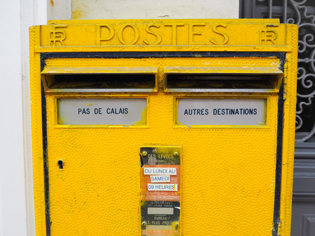 Le Touquet, France - December 2017: Bright yellow metal postbox from the French National Post with a dedicated compartment for Pas De Calais regionのeditorial素材