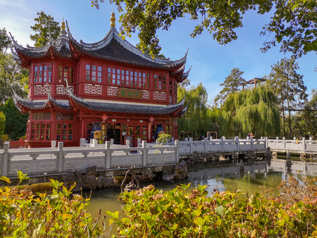 September 2018 - Brugelette, Belgium: the tea pavilion in traditional red color with blue roof beams in the Chinese garden in the zoo Pairi Daizaのeditorial素材