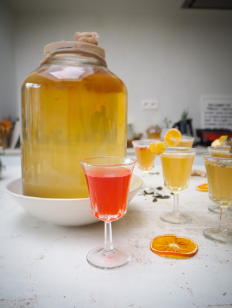 Multiple glasses with a variety of flavored kombucha tea such as cinnamon, citrus, turmeric and...